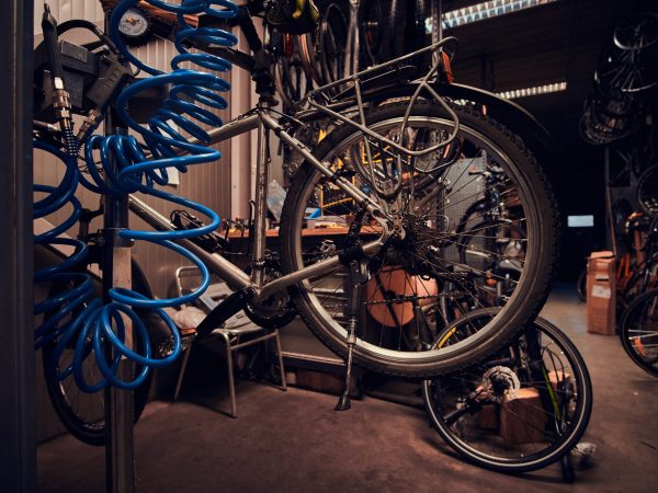 Busy workshop with broken mountain bicycle on the table.